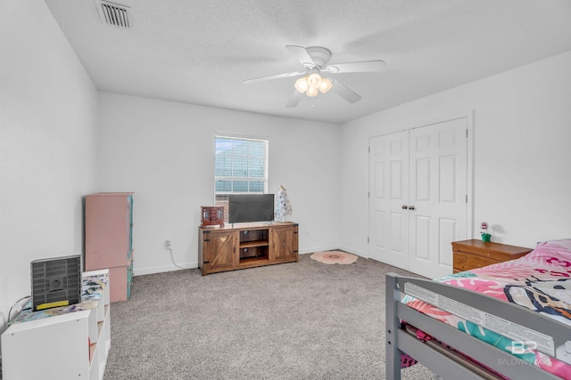 carpeted bedroom with baseboards, visible vents, ceiling fan, a textured ceiling, and a closet