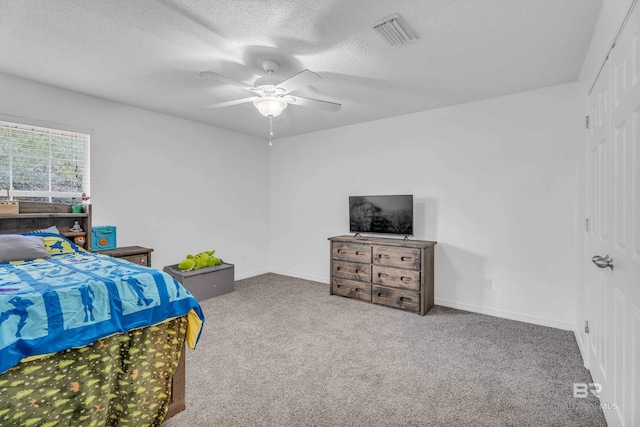 bedroom featuring carpet floors, visible vents, a textured ceiling, and baseboards