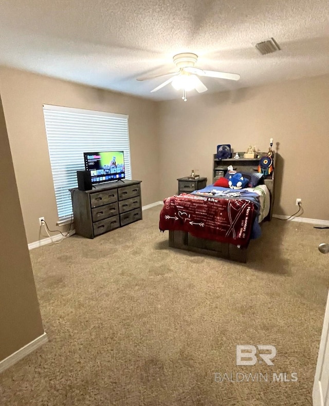 carpeted bedroom with a textured ceiling and ceiling fan