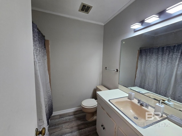 114 Spruce Ave, Brewton, AL 36426 - bathroom featuring crown molding, wood finished floors, toilet, vanity, and baseboards