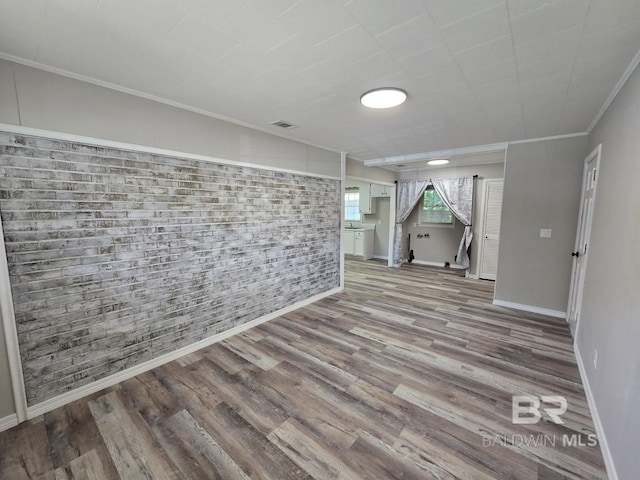 114 Spruce Ave, Brewton, AL 36426 - below grade area with wood finished floors, baseboards, brick wall, and crown molding