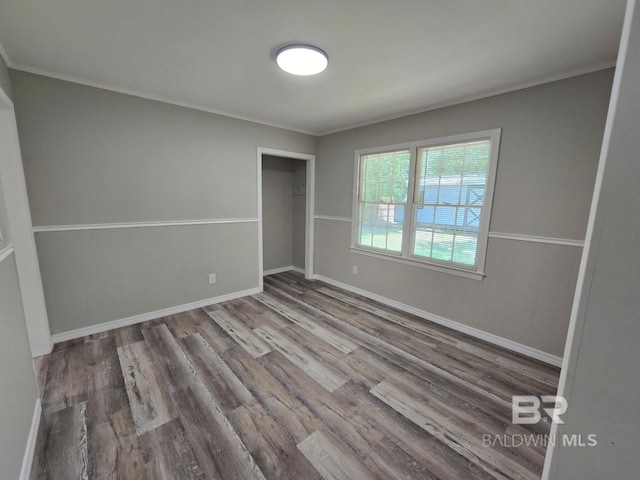 114 Spruce Ave, Brewton, AL 36426 - unfurnished bedroom with wood finished floors, a closet, baseboards, and crown molding