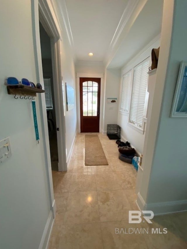 entryway with light tile patterned flooring and ornamental molding