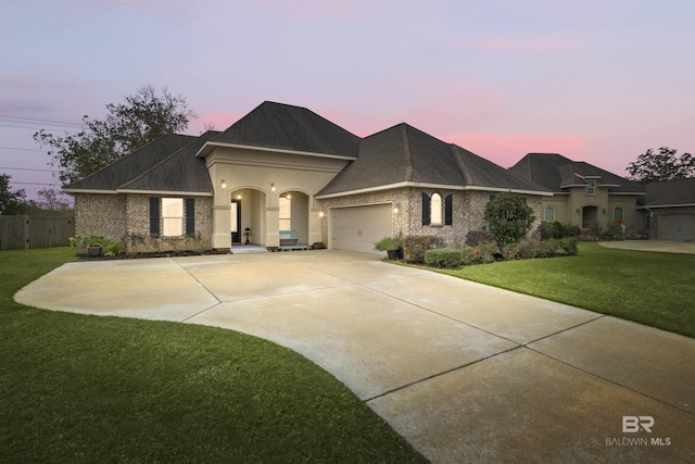 view of front of home with a garage and a yard