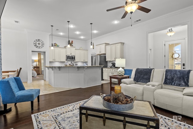 living room with ceiling fan, wood-type flooring, and ornamental molding