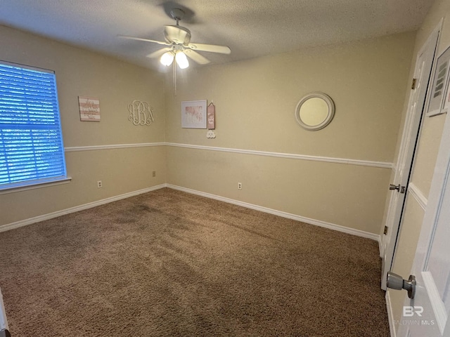 carpeted spare room featuring baseboards, a ceiling fan, and a textured ceiling