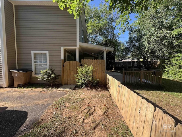 view of property exterior with fence and a gate