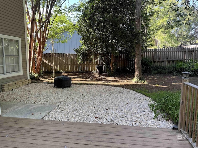 wooden terrace with a fenced backyard