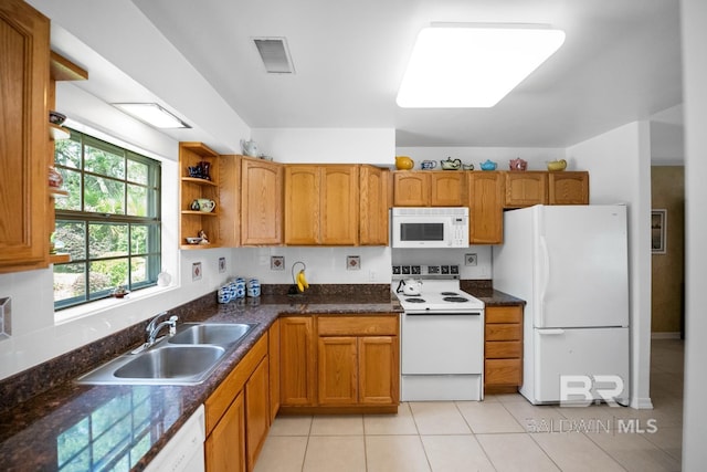 35788 Boykin Blvd, Lillian, AL 36549 - kitchen with a sink, white appliances, brown cabinetry, light tile patterned floors, and visible vents