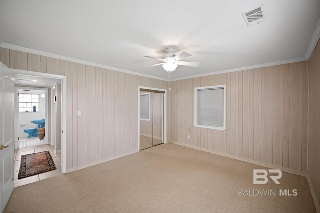 35788 Boykin Blvd, Lillian, AL 36549 - unfurnished bedroom with crown molding, carpet flooring, wood walls, a ceiling fan, and visible vents