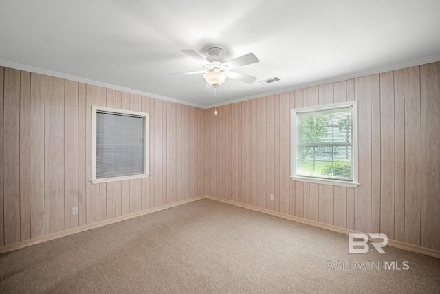 35788 Boykin Blvd, Lillian, AL 36549 - carpeted empty room featuring visible vents, a ceiling fan, and wooden walls