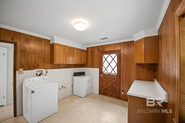 35788 Boykin Blvd, Lillian, AL 36549 - clothes washing area with visible vents, ornamental molding, washing machine and dryer, light floors, and cabinet space