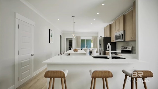 6158 Milo Loop, Gulf Shores, AL 36542 - kitchen with stainless steel appliances, a breakfast bar area, light wood-style flooring, a peninsula, and recessed lighting