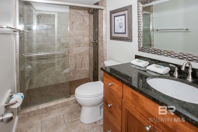 bathroom with a shower with door, tile floors, large vanity, and toilet