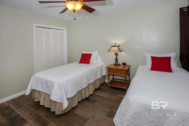 bedroom with ceiling fan, dark wood-type flooring, and a closet