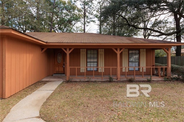 view of front of property with a shingled roof, fence, and a porch