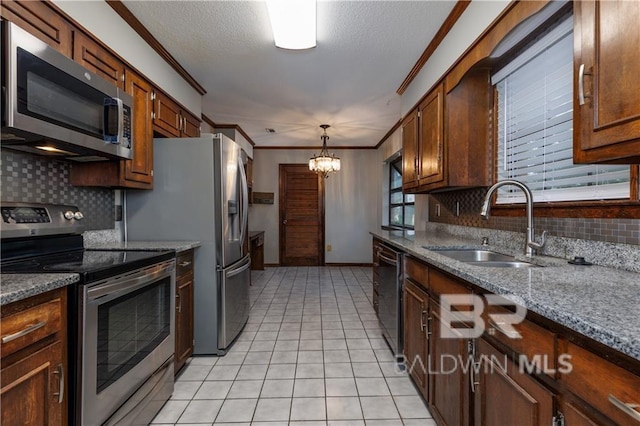 kitchen with a chandelier, crown molding, appliances with stainless steel finishes, a sink, and light tile patterned floors