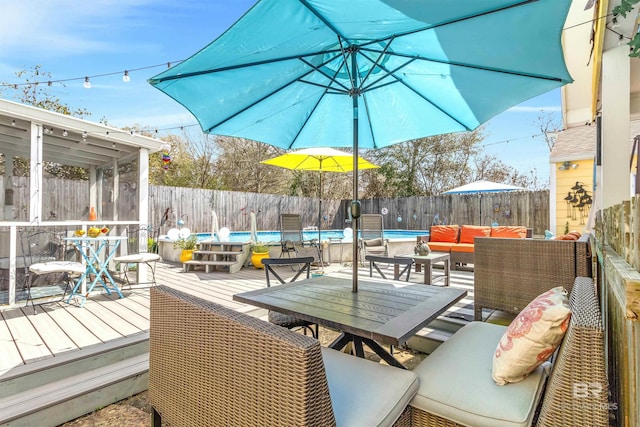 wooden deck with an outdoor living space, outdoor dining area, a fenced backyard, and a fenced in pool