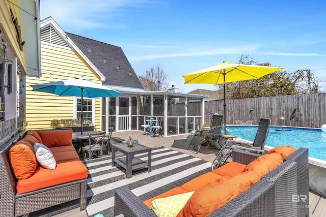 view of patio / terrace with fence, a fenced in pool, a sunroom, and an outdoor hangout area