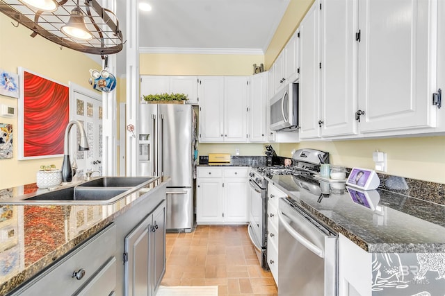 kitchen with ornamental molding, white cabinets, stainless steel appliances, and a sink