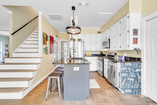 kitchen with visible vents, white cabinetry, stainless steel appliances, and a sink