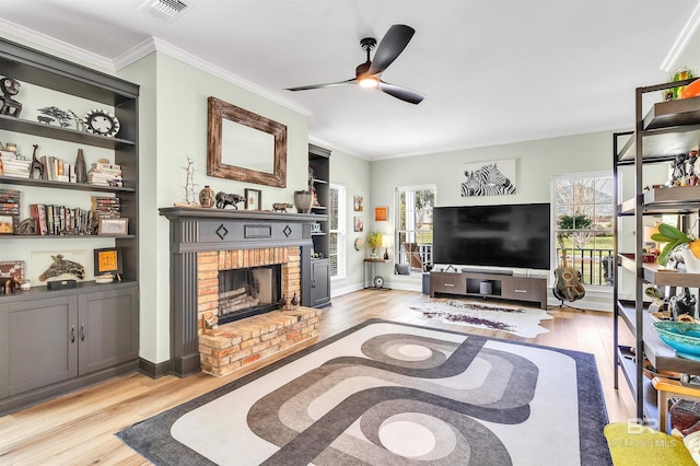 living area featuring a brick fireplace, light wood-style flooring, a wealth of natural light, and ceiling fan