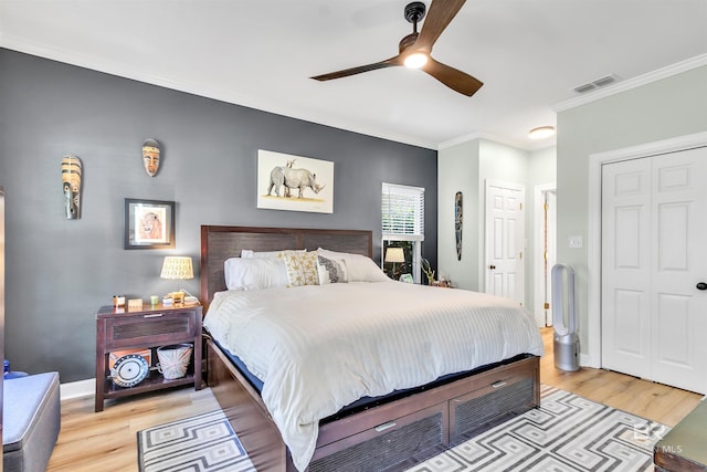 bedroom featuring visible vents, ceiling fan, baseboards, ornamental molding, and light wood-style flooring