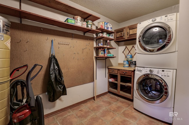 clothes washing area with a textured ceiling, light tile patterned flooring, and stacked washer and clothes dryer