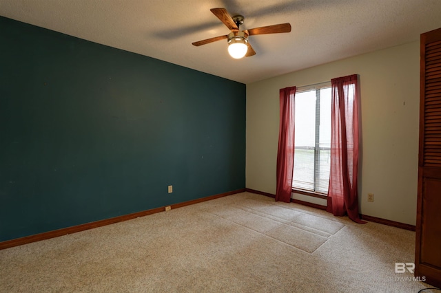 carpeted empty room with ceiling fan and a textured ceiling