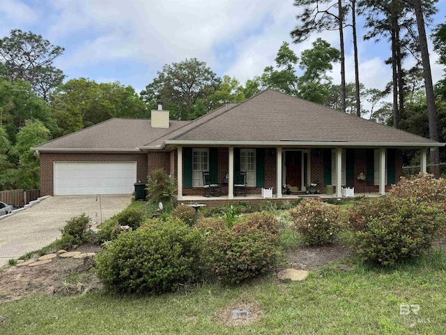 ranch-style house with an attached garage, a porch, a chimney, concrete driveway, and brick siding