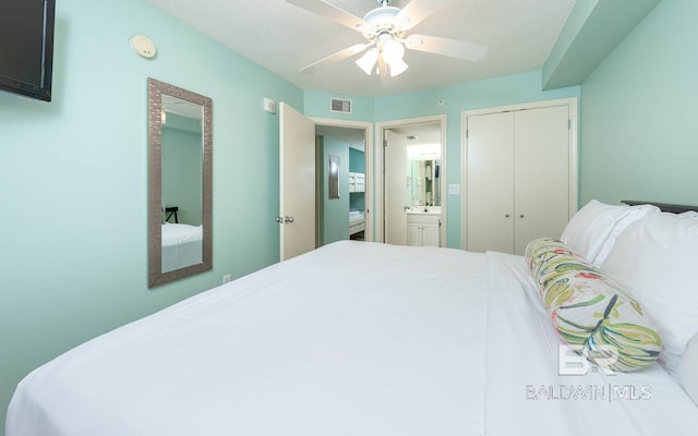 bedroom with ceiling fan, a closet, ensuite bath, and a textured ceiling