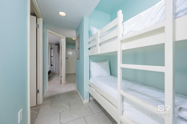 bedroom featuring light tile patterned flooring and a textured ceiling