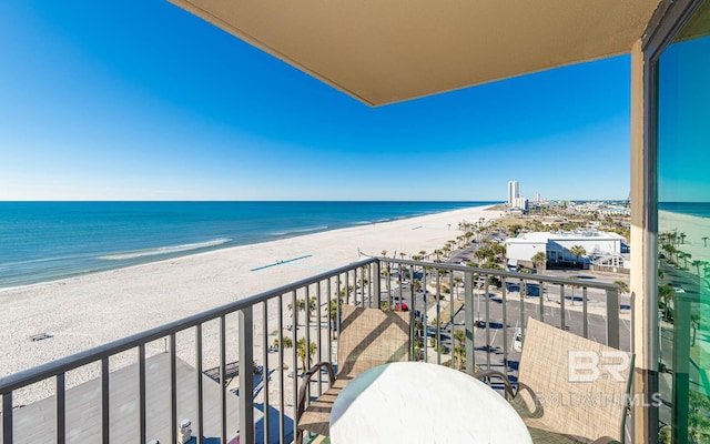 balcony with a water view and a view of the beach