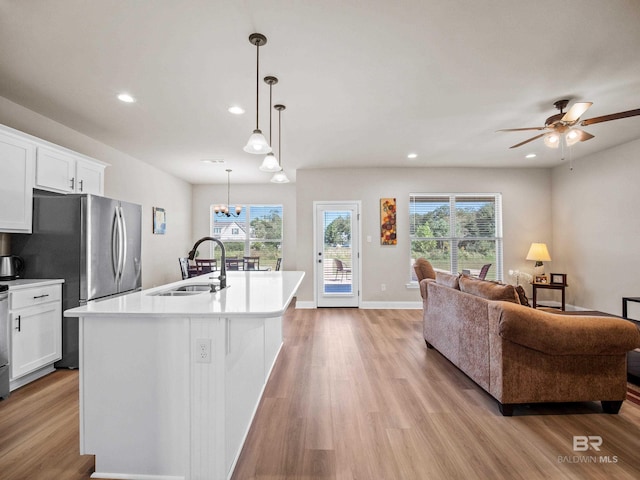 kitchen with white cabinetry, sink, decorative light fixtures, a center island with sink, and ceiling fan with notable chandelier