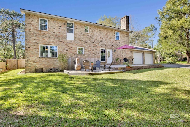back of property featuring fence, a chimney, a yard, and a patio