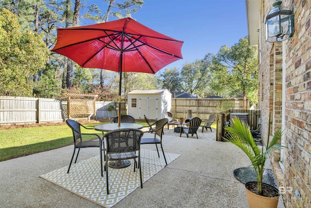 view of patio featuring a storage unit, a fenced backyard, an outbuilding, and outdoor dining area