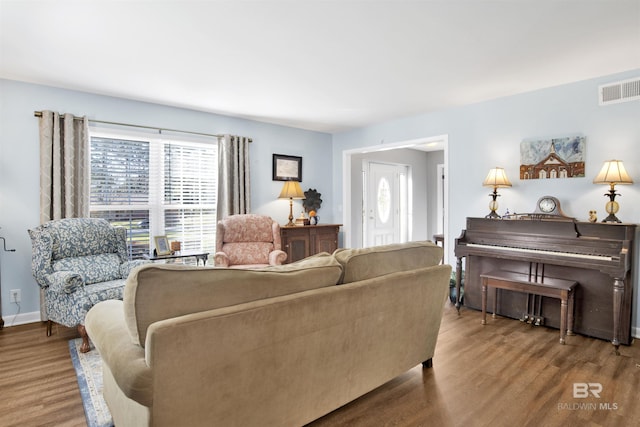 living area featuring visible vents and wood finished floors