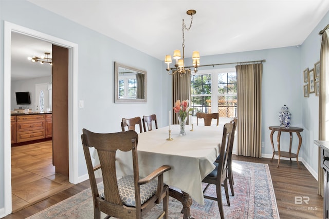 dining room with an inviting chandelier, light wood-style flooring, and baseboards