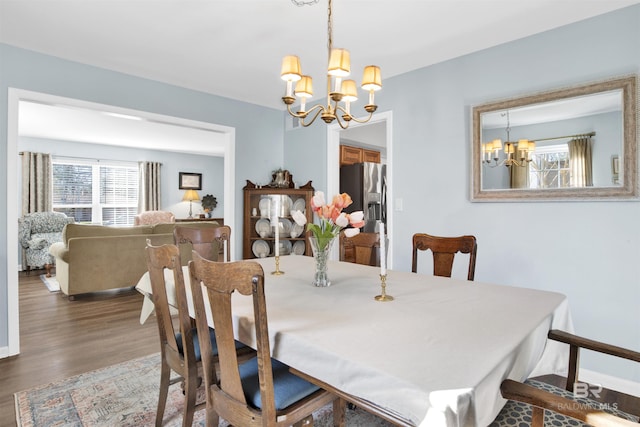 dining space with a notable chandelier and wood finished floors