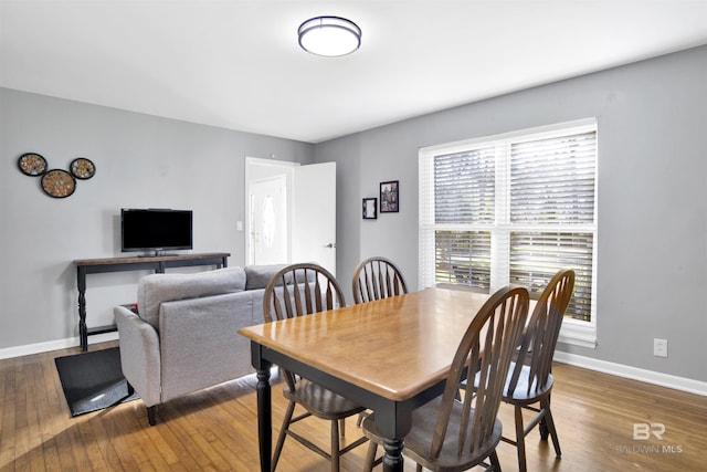 dining room with baseboards and hardwood / wood-style flooring