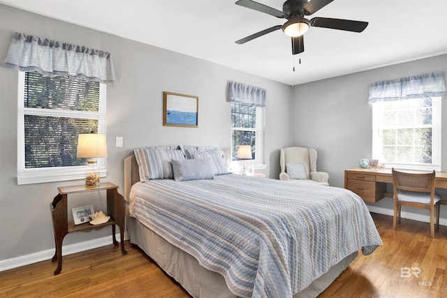bedroom featuring baseboards, wood finished floors, and ceiling fan