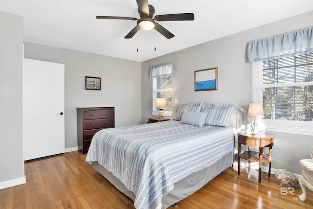 bedroom with wood finished floors, ceiling fan, and baseboards