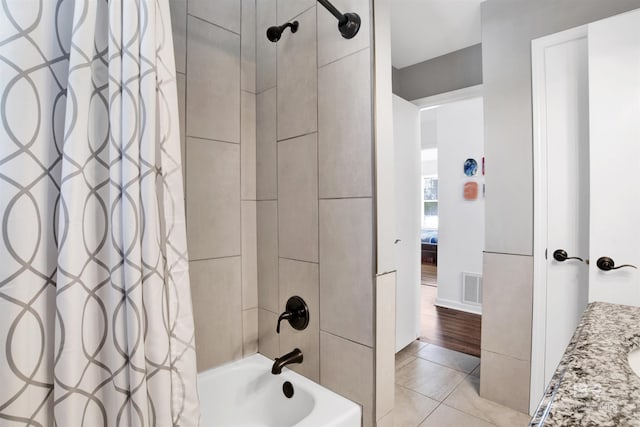 full bathroom with visible vents, shower / bath combo, tile patterned flooring, and baseboards