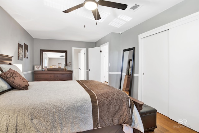 bedroom featuring visible vents, wood finished floors, a ceiling fan, and a closet