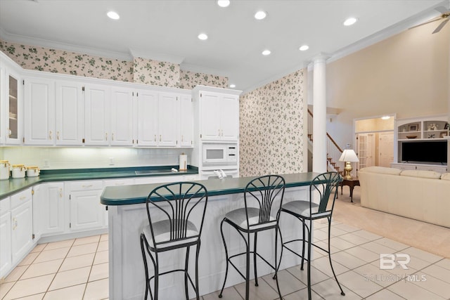 9330 Timbercreek Blvd, Daphne, AL 36527 - kitchen featuring ornamental molding, white appliances, dark countertops, a kitchen bar, and wallpapered walls