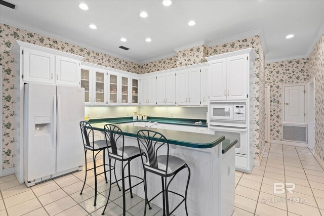 9330 Timbercreek Blvd, Daphne, AL 36527 - kitchen with white appliances, wallpapered walls, ornamental molding, light tile patterned flooring, and white cabinets