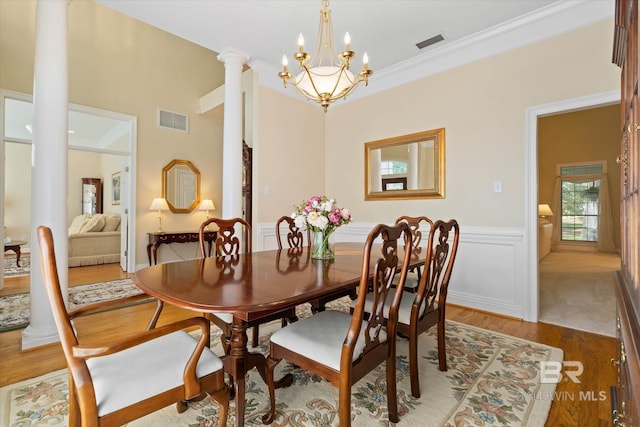 9330 Timbercreek Blvd, Daphne, AL 36527 - dining space featuring ornate columns, wood finished floors, a chandelier, a wainscoted wall, and ornamental molding