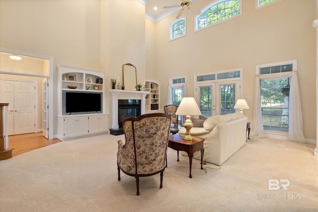 9330 Timbercreek Blvd, Daphne, AL 36527 - living area featuring light carpet, a high ceiling, a ceiling fan, a glass covered fireplace, and french doors
