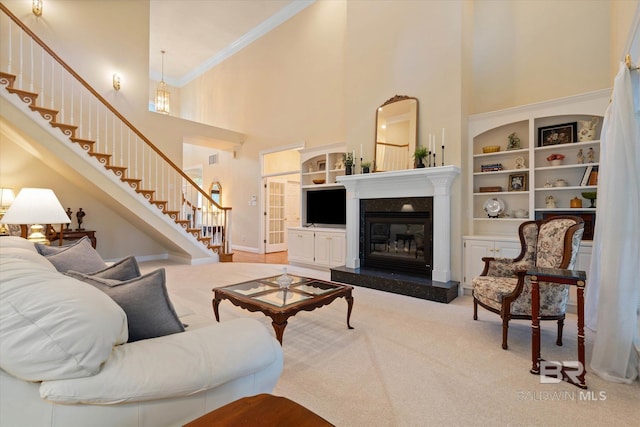 9330 Timbercreek Blvd, Daphne, AL 36527 - living room featuring a high ceiling, stairway, crown molding, built in features, and a glass covered fireplace