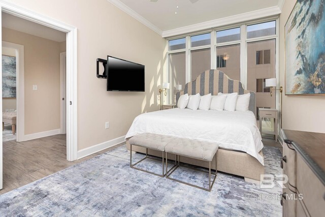 bedroom with ornamental molding and light wood-type flooring